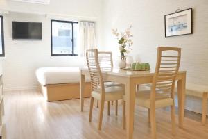 - une salle à manger avec une table, des chaises et un lit dans l'établissement Petit Grande Miyabi, à Tokyo