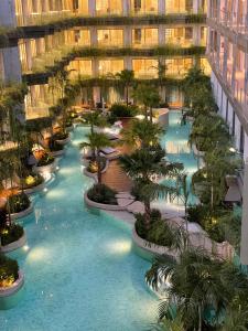una vista sulla piscina in un edificio con palme di Panwaburi Beachfront Resort - SHA Extra Plus a Panwa Beach