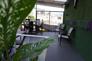 un restaurant avec des chaises, des tables et un mur vert dans l'établissement Hostal Guatefriends, à Guatemala