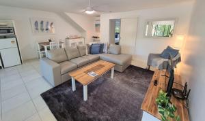 a living room with a couch and a table at Noosa River Retreat Holiday Apartments in Noosaville