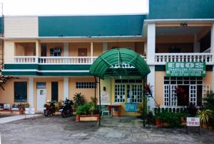 un edificio con un dosel verde delante de él en RedDoorz @ Eros Travellers Pensione, en Iloilo City