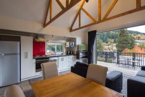 a kitchen and living room with a table and a view at Pinewood Lodge and Apartments in Queenstown