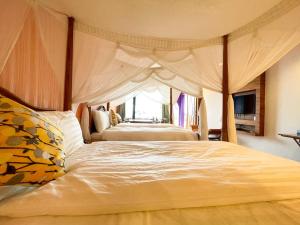 a bedroom with a large bed with a canopy at 八村 Resort in Xiaoliuqiu