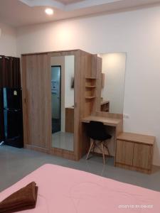 um quarto com uma secretária de madeira e um espelho em The S อพาร์ทเม้นท์ em Ban Pra Dok