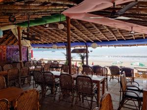 un restaurante con mesas y sillas y la playa en Rococo Pelton beach huts Palolem Beach goa, en Palolem