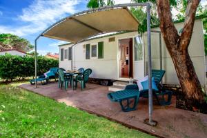 een patio met stoelen en een tafel voor een huis bij Village & Camping La Foce in Valledoria