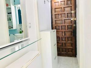 baño con puerta de madera y espejo en Investingspain Studio beach paradise front sea views swimming pool, en Platja d'Aro