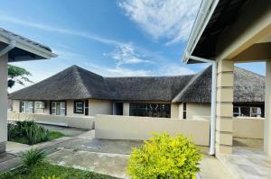 a house with a thatched roof at Hinterland Lodge in Ulundi