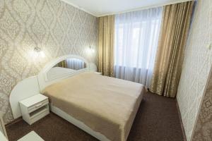 a bedroom with a white bed and a window at Hotel Mir in Kyiv