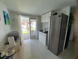 a kitchen with a stainless steel refrigerator and a sink at STUDIO S at JAN THIEL Curacao in Jan Thiel