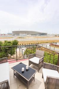 patio con sillas y mesa y vistas a la playa en Olymp Rooms, en Adler