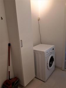 a white washer and dryer in a white room at Nabo til domkirken in Viborg +5 photos