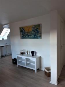 uma sala de estar com um armário branco e um quadro na parede em Nabo til domkirken em Viborg