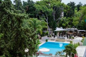 an overhead view of a pool with umbrellas and trees at Rodos Park in Rhodes Town