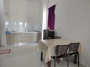 a dining room table with chairs and a kitchen at STUDIO SUITE HOMESTAY KLIA in Sepang
