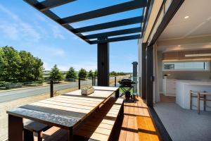 une grande terrasse avec une table et un grill sur une maison dans l'établissement Lake Luxe - Taupo, à Taupo