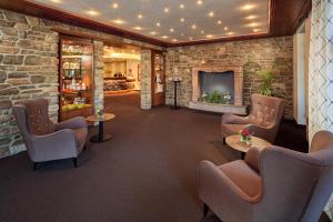 a waiting room with chairs and a fireplace at Hotel Sommer-Haus am See in Füssen