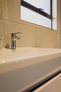 y baño con lavabo blanco y espejo. en Villa Portia, en Johannesburgo