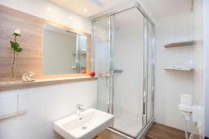 Un baño con ducha de cristal y lavabo. en Landhaus Gudrun, en Tux