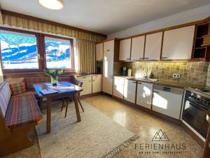 eine Küche mit einem Tisch und einem Esszimmer in der Unterkunft Ferienwohnung an der Familienabfahrt in Brixen im Thale