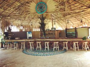 a bar with stools and a clock on the ceiling at Mallara RestSafari (Cabana & Family Restaurant) in Malasnegalewewa