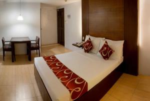 Habitación de hotel con cama y mesa en ACL Suites en Manila