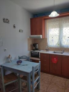 a kitchen with a table and a sink and a stove at Villa Paris in Xerokampos