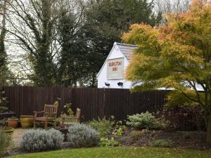 een klein wit huis met een bord op een hek bij Burlton Inn in Burlton