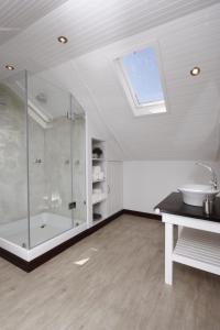a bathroom with a glass shower and a sink at The Potting Shed Guest House in Hermanus