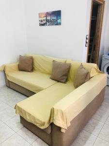a large yellow couch sitting in a room at fanis sweet home in Kampos Paros