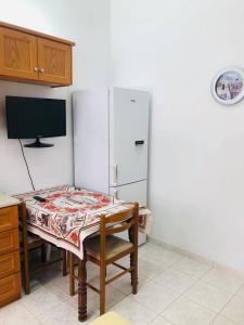 a kitchen with a table and a white refrigerator at fanis sweet home in Kampos Paros