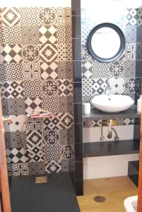 een badkamer met zwarte en witte tegels en een wastafel bij Spiti Anatoli in Karfás