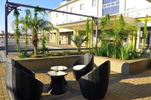 patio z krzesłami i stołami przed budynkiem w obiekcie Travelodge w mieście Gaborone