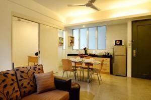 a kitchen and living room with a table and chairs at One-Stop Residence & Hotel in Kuala Lumpur