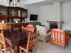 Vacaciones en A Costa da Morte في Buño: غرفة معيشة مع طاولة وكراسي خشبية