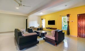 a living room with two couches and a tv at Treebo Trend La Paradise in Mahabaleshwar