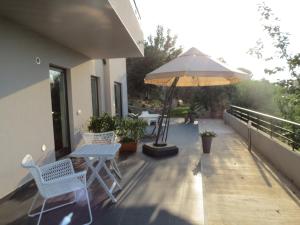 a patio with a table and an umbrella at La Casa del Riccio in Tindari