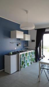a kitchen with a sink and a stove in a room at La Casa del Riccio in Tindari