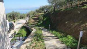 a road next to a hill with a car on it at La Casa del Riccio in Tindari