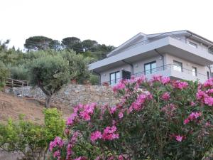 a house with pink flowers in front of it at La Casa del Riccio in Tindari