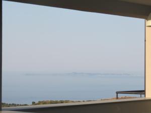 a large window with a view of the beach at La Casa del Riccio in Tindari