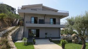 a white house with stairs and a balcony at La Casa del Riccio in Tindari