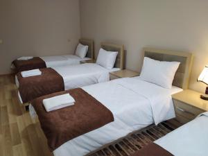 a hotel room with three beds with towels on them at Gold Hotel Quba in Quba