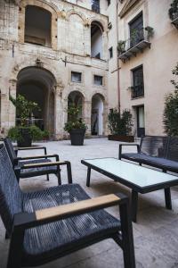 a group of tables and benches in front of a building at PALAZZO SANTAMARINA Luxury Suite & Spa in Palermo