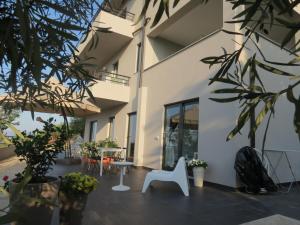 a courtyard of a building with plants and a white chair at La Casa del Riccio in Tindari