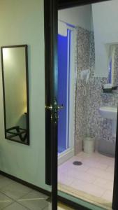 Baño con puerta azul y espejo en B&B La Dimora Di Nettuno, en Nápoles