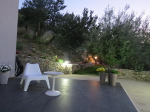 a white table and a white chair on a patio at La Casa del Riccio in Tindari