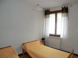 1 dormitorio con cama y ventana en LOU FILADOUR 4 PERSONNES 1er étage en Jausiers