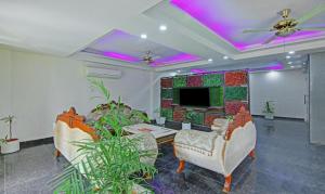 a living room with two chairs and a tv at Itsy by Treebo - Nyra Sector 22 in Gurgaon