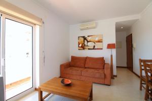 a living room with a couch and a table at Falesia Beach Apartment in Albufeira